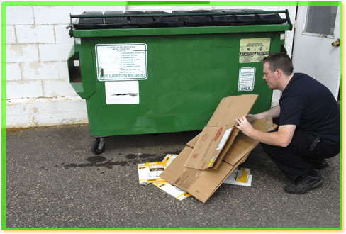 Worker cleaning around dumpster.