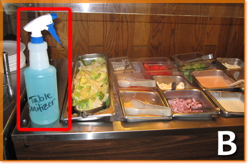 A sanitizer bottle sitting on a salad bar.