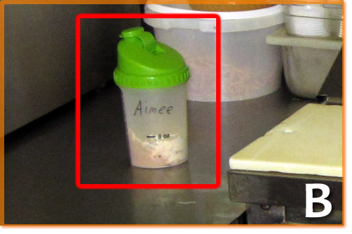 A labeled and covered drink comtainer sitting on a food prep area.